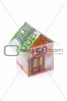 House built with Euro money bills isolated on white background