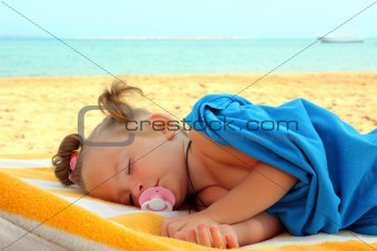 little girl sleeping on beach
