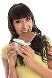 Beautiful girl eating a block of chocolate