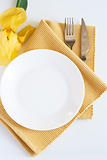 Fork, knife, plate and yellow iris flower