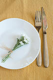 Fork, knife, plate and small white flowers