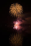Colorful fireworks on the black sky background and water reflect