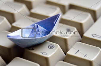 Blue origami boat on keyboard