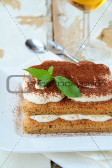 Traditional Italian dessert tiramisu on white plate