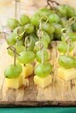 appetizer canape cheese with white grapes on bamboo skewers