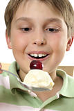 Smiling boy holding large scoop of ice cream