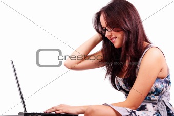 Pretty woman with confused expression working on laptop