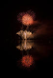 Colorful fireworks on the black sky background and water reflect
