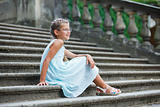 beautiful girl sits on on the stairs in a park