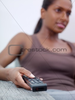 woman holding remote control and watching tv