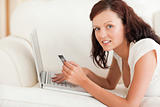 Dark-haired woman doing some online shopping looking into the camera