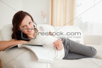 Young woman studying on the sofa looking into the camera