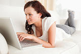Relaxed red-haired woman searching the internet