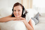 Relaxed red-haired woman with headphones looking into the camera