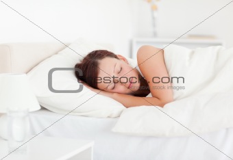Beautiful Red-haired woman lying in bed sleeping