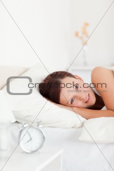 Close up of a Red-haired woman lying in bed looking into the camera