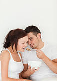 Close up of a man feeding cereal to his wife