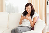 Woman sitting on a sofa while texting