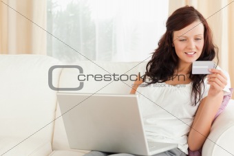 Young woman with a laptop and a card