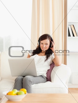 Cute woman with a notebook listening to music