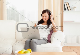 Woman working with notebook while listening to music