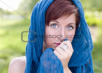 Outdoor Portrait of Pretty Blue Eyed Young Red Haired Adult Female with Blue Scarf.