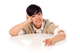Smiling Mixed Race Young Adult Female Sitting at White Table Isolated on a White Background.