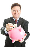 Happy Businessman Saves in Piggy Bank