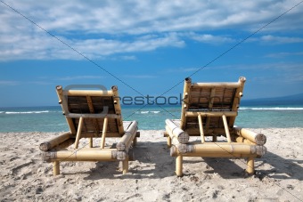 Wooden deckchairs on empty beach