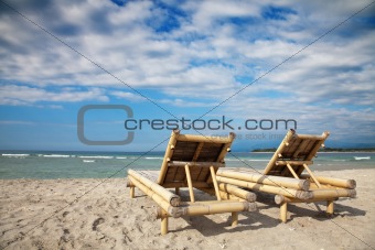 Wooden deckchairs on empty beach