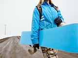 Woman carrying snowboard.