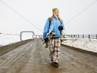 Woman carrying snowboard.