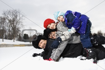 Family stacked in snow.