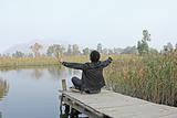 Man resting on a pontoon by a lake 