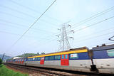 passenger trains in motion and power tower on background 