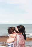 Mother hugging her baby over sea 