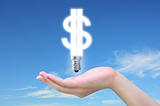 light bulb model of a dollar symbol in women hand on sky
