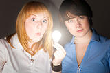 two business women with bulb