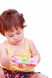 Baby in yellow shirt playing with toys