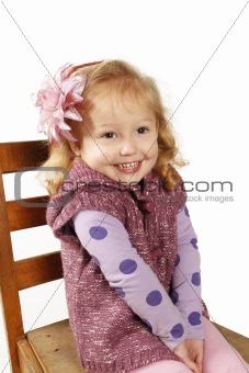 Pretty little girl sitting on a chair