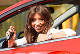 Beautiful young  woman in the new car with keys