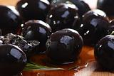 Black olives on a wooden table.