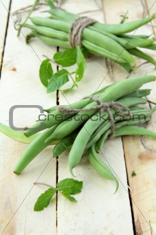 pods of green peas on a wooden table