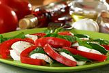 Salad caprese with fresh tomatoes, cheese and basil.