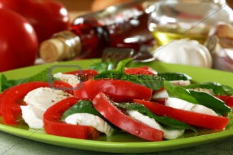Salad caprese with fresh tomatoes, cheese and basil.