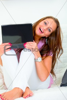 Cheerful lovely woman looking from laptop
