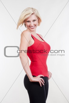 sexy blond woman in red top standing, smiling - isolated on white