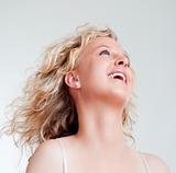 portrait of a young blond woman looking, smiling - isolated on light gray