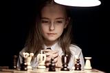 Girl playing chess under lamp