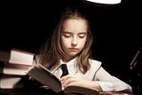 Girl reading book under lamp